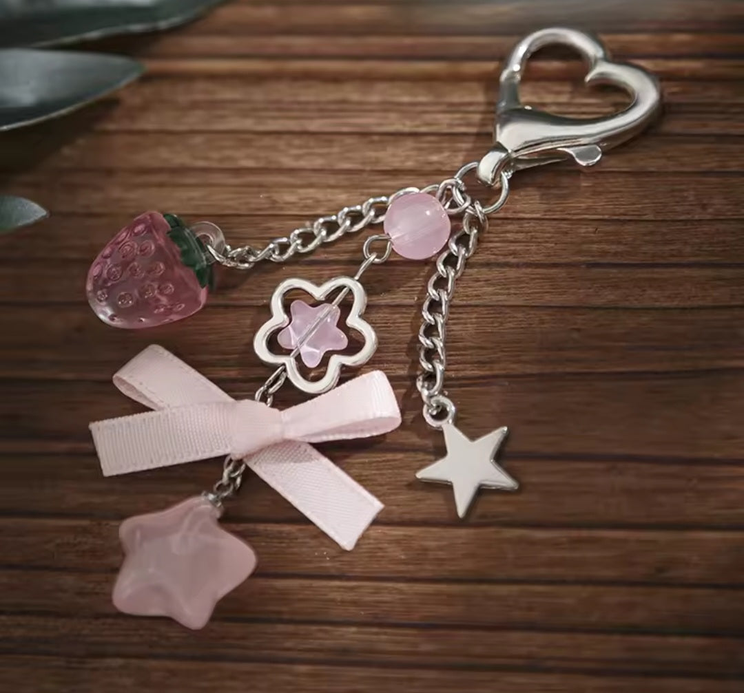 Pink charm keyring with strawberry, bow, star and flower charms on a heart clasp